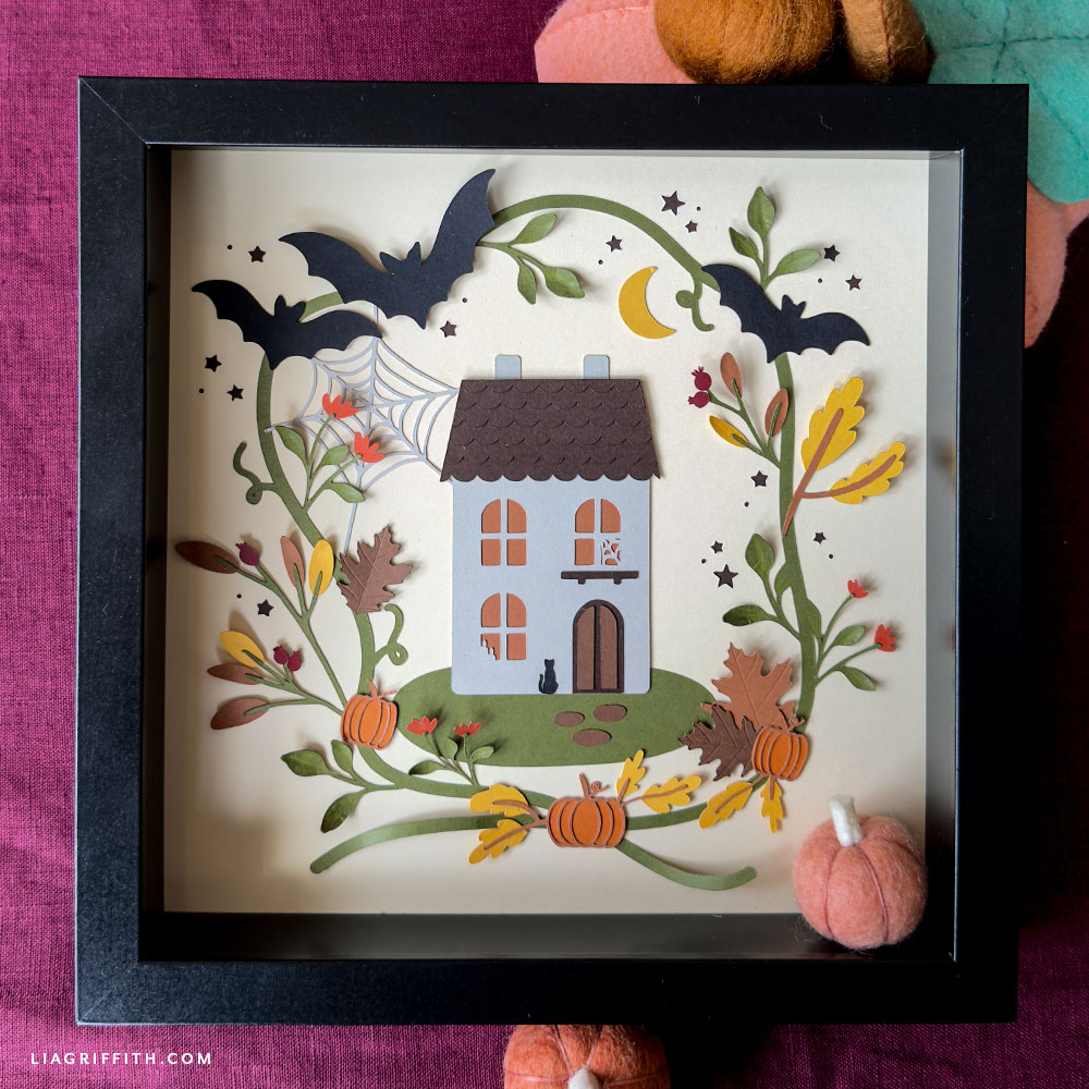 Papercut Halloween art in orange and brown cardstock inside a frame