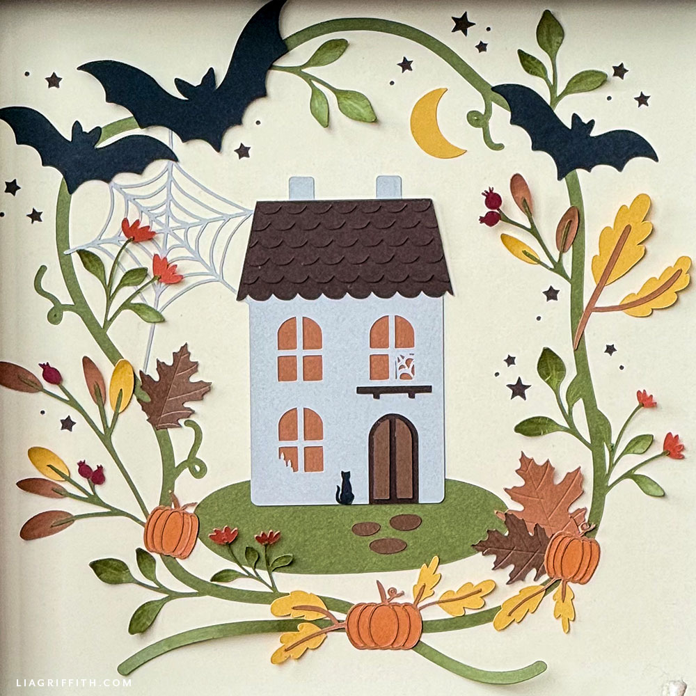 Papercut Halloween art in orange and brown cardstock inside a frame